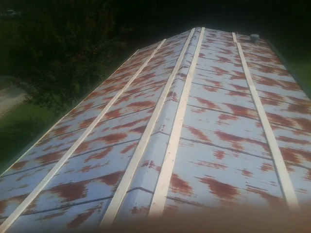 Rusted metal roof panels with new wood purlins before replacement — Storm Damage Roof Repair in West Townsend by Roofing Brothers