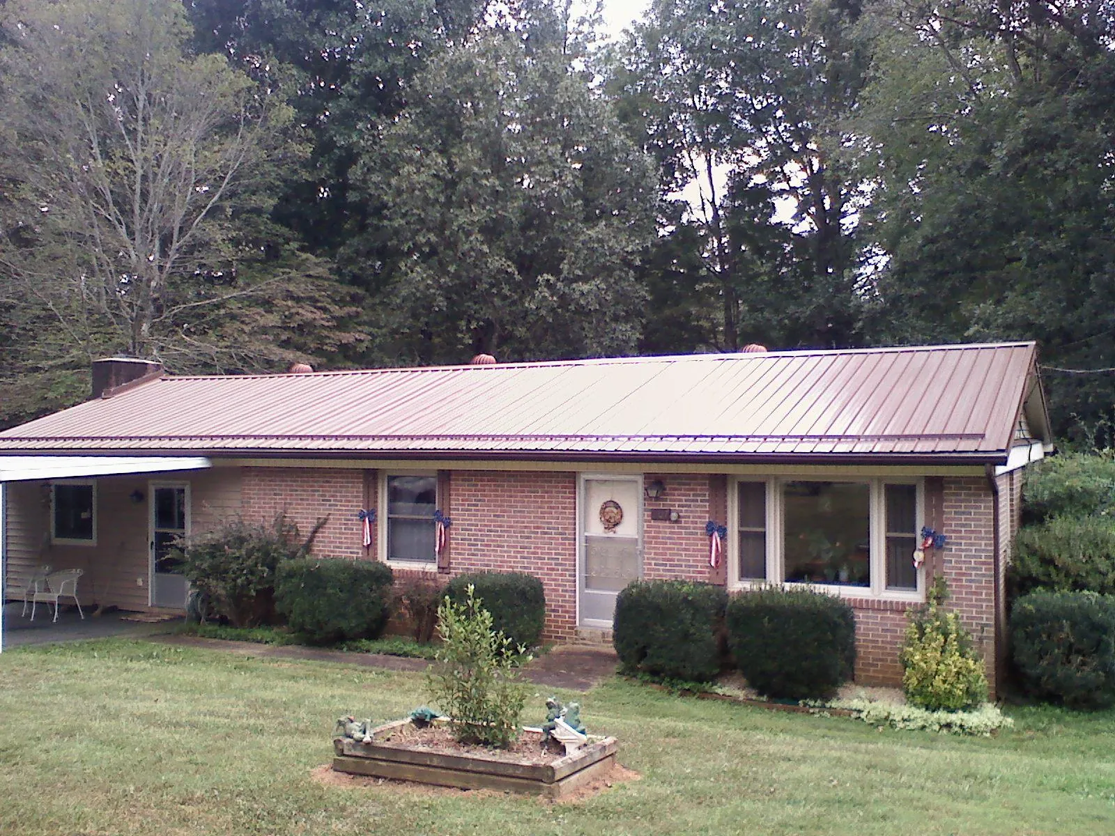 Bronze metal roof on a brick ranch home with a carport in West Townsend