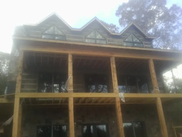 Dormers and porch framing on a large log home under construction — Roof Coating work by our crew in West Townsend