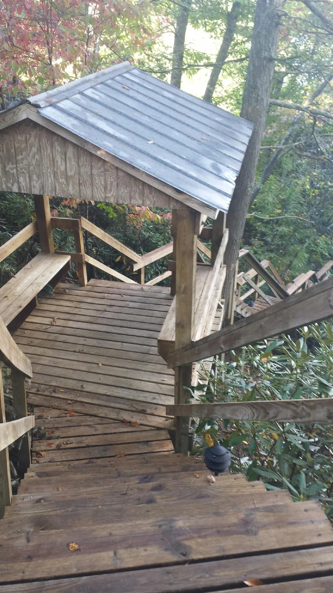 Metal roofed shelter over wooden steps on a wooded walkway — Skylight Repair & Installation work by our crew in West Townsend