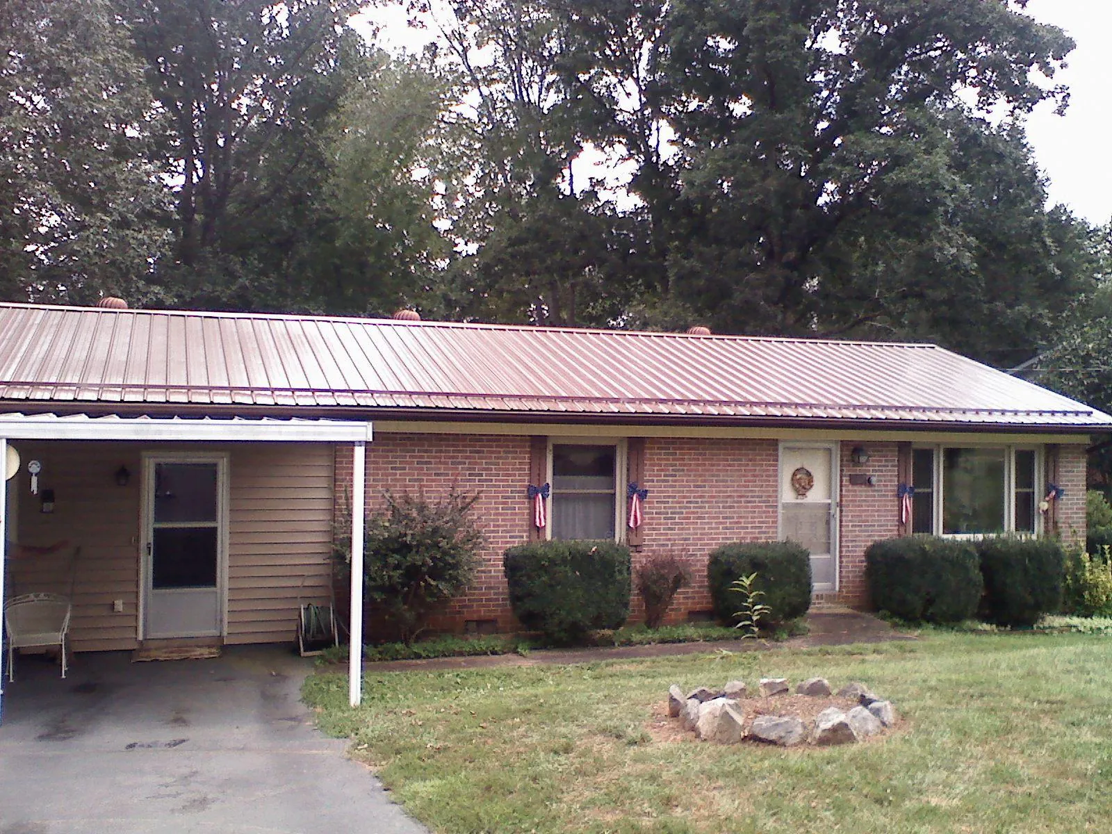 Bronze metal roof and carport on a brick ranch home — Roof Repair work by our crew in West Townsend